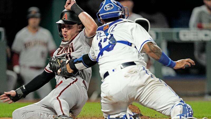 Arizona Diamondbacks' Jake McCarthy is tagged out by Kansas City Royals catcher Salvador Perez...