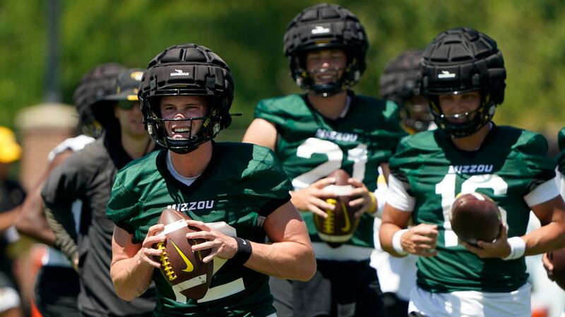 Missouri quarterback Brady Cook, front left, takes part in a drill during an NCAA college...