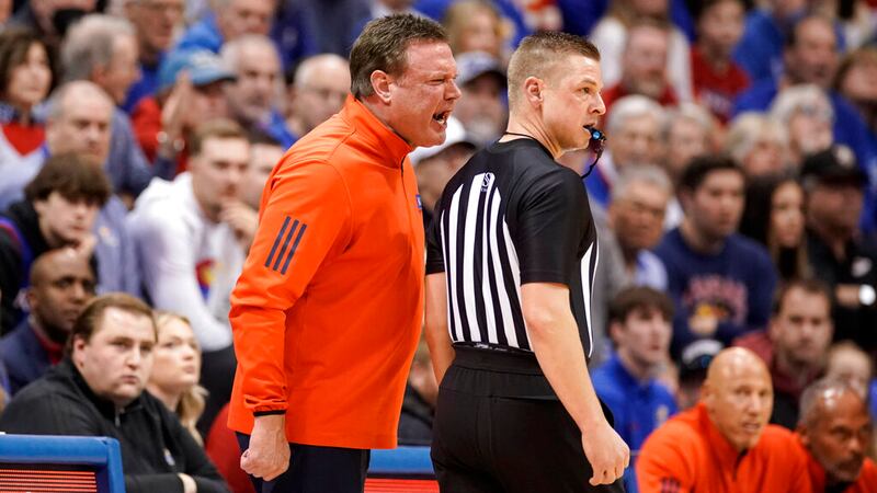 Kansas head coach Bill Self gets in the ear of an official just before receiving a technical...