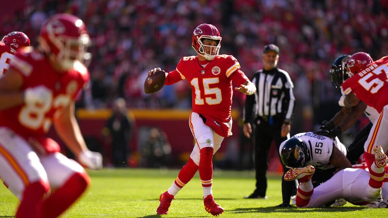 Kansas City Chiefs quarterback Patrick Mahomes runs as he throws as touchdown pass to wide...