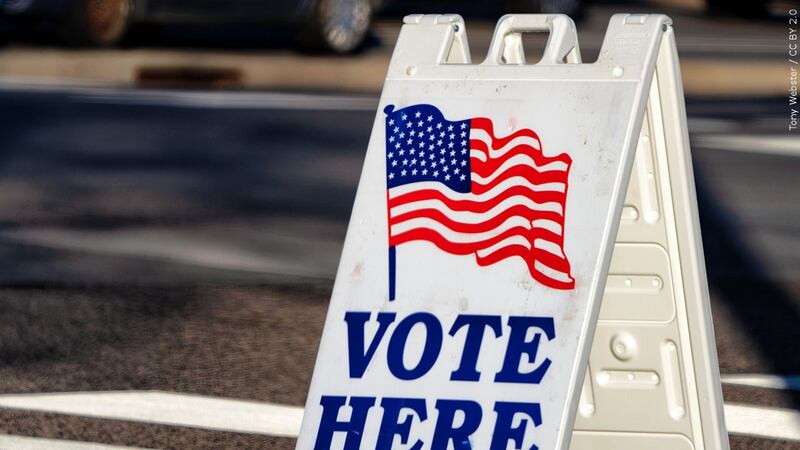 FILE — A "Vote Here" sign sits in front of an election site.