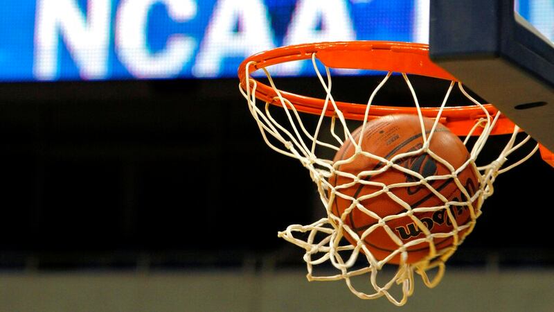 In this March 20, 2010, file photo, a ball flicks through the net in front of the NCAA logo on...