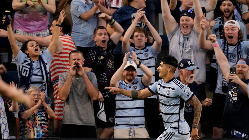 Sporting Kansas City forward Alán Pulido celebrates after scoring a goal during the first half...