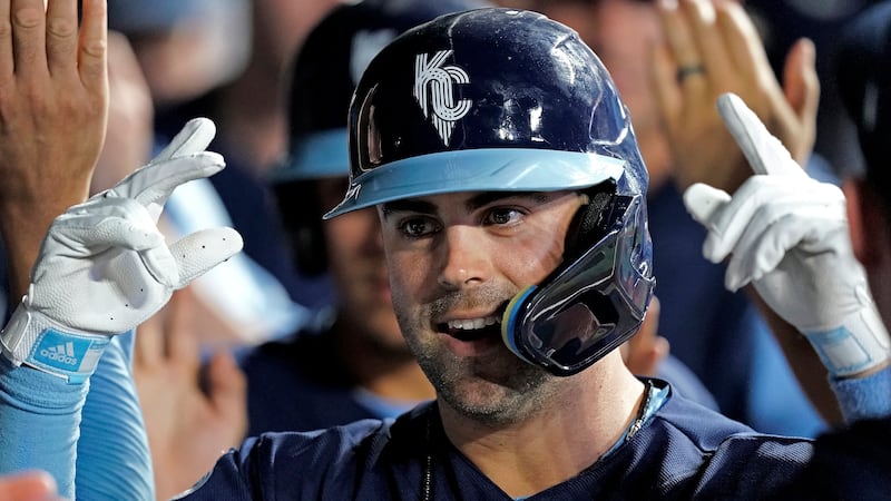 Kansas City Royals' Whit Merrifield celebrates in the dugout after hitting a two-run home run...