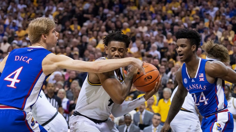 Missouri's DeAndre Gholston, center, is fouled by Kansas' Gradey Dick, left, as Kansas' K.J....