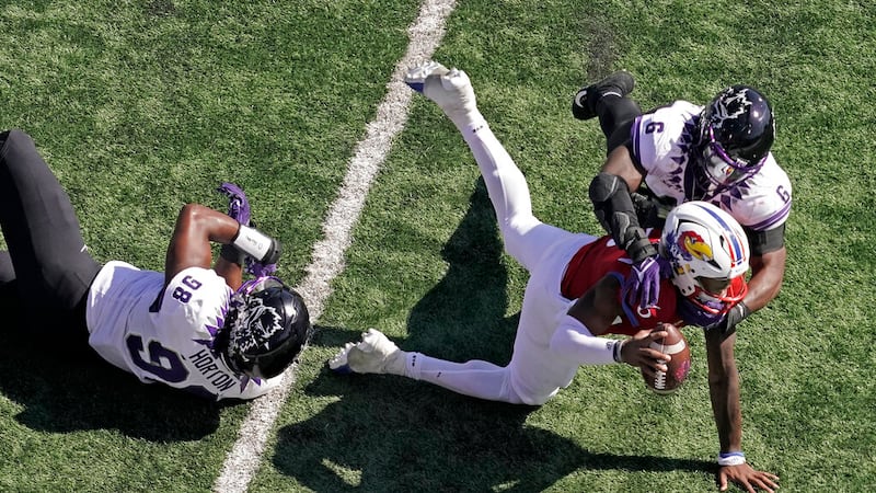 Kansas quarterback Jalon Daniels is sacked by TCU linebacker Jamoi Hodge (6) during the first...