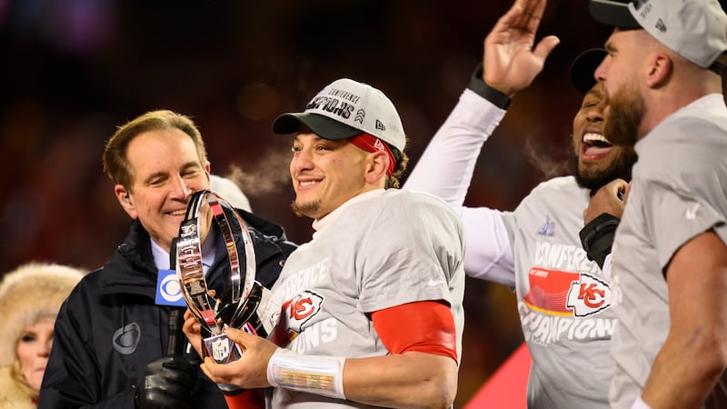 Kansas City Chiefs quarterback Patrick Mahomes holds the Lamar Hunt Trophy as Jim Nantz of...